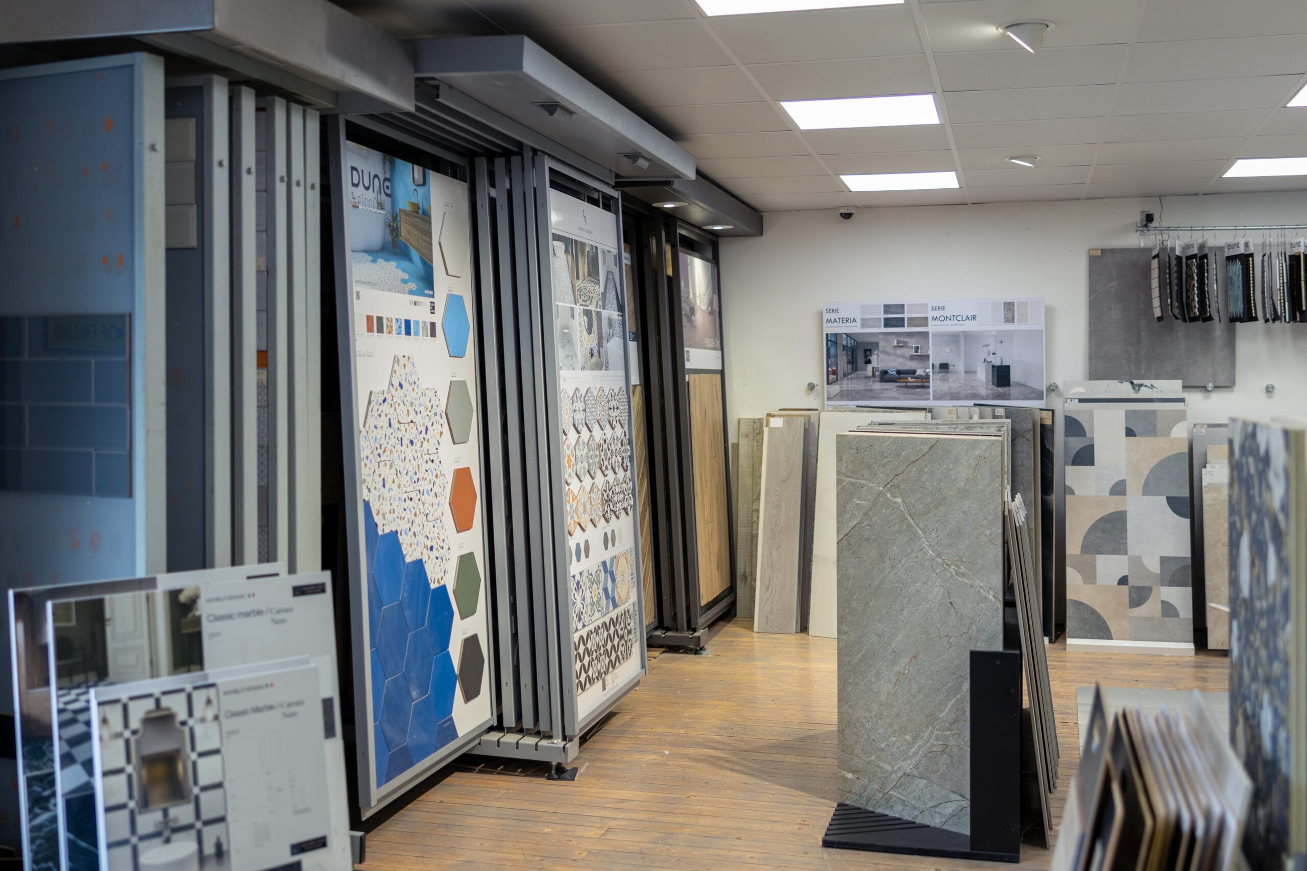 Tile showroom display with blue hexagon, terrazzo, geometric and marble porcelain tile samples