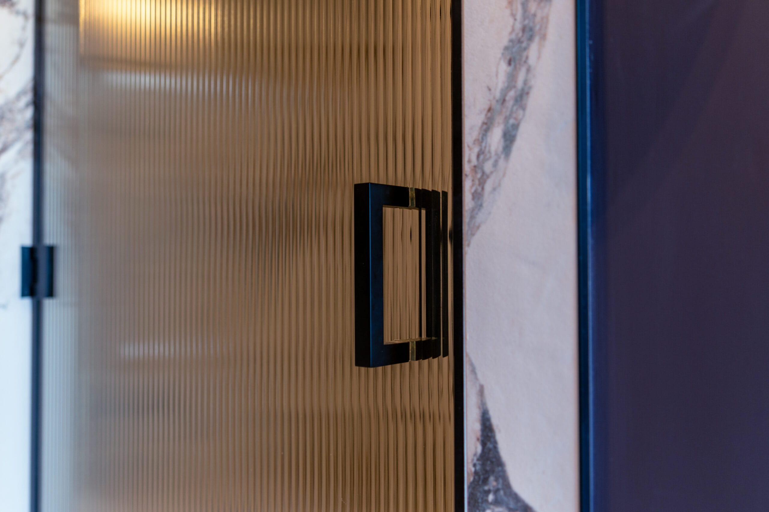 Fluted bronze glass shower screen panel with matte black square door handle
